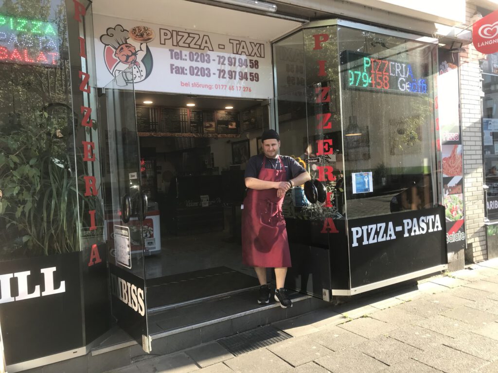 Burak Kalkan vor seiner Pizzeria; Foto: Peter Ansmann